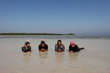 Turistler, 8 Eylül 2018 'de Endonezya' nın Karimun Jawa Jepara plajında neşeyle oynarlar.