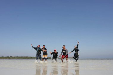 Turistler, 8 Eylül 2018 'de Endonezya' nın Karimun Jawa Jepara plajında neşeyle oynarlar.