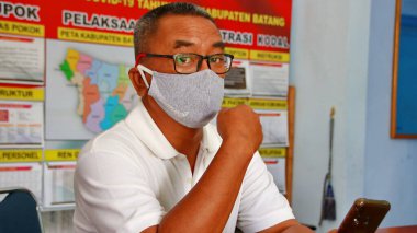  Virüsleri ve kirli havayı önlemek için maske takan bir adam, Batang Endonezya, 7 Mayıs 2020