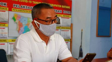  Virüsleri ve kirli havayı önlemek için maske takan bir adam, Batang Endonezya, 7 Mayıs 2020