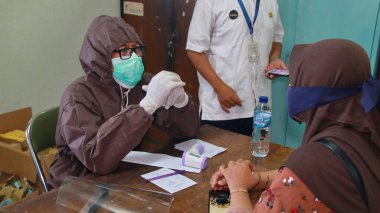 Toplum, Batang, Endonezya, 27 Mayıs 2020 'de hızlı bir test yaparken bulanık seçici odaklanma ve gürültü imajı çalışanları