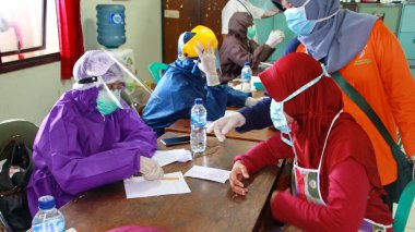 Toplum, Batang, Endonezya, 27 Mayıs 2020 'de hızlı bir test yaparken bulanık seçici odaklanma ve gürültü imajı çalışanları