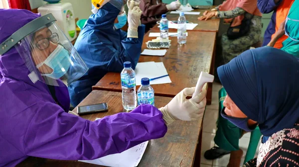 Toplum, Batang, Endonezya, 27 Mayıs 2020 'de hızlı bir test yaparken bulanık seçici odaklanma ve gürültü imajı çalışanları