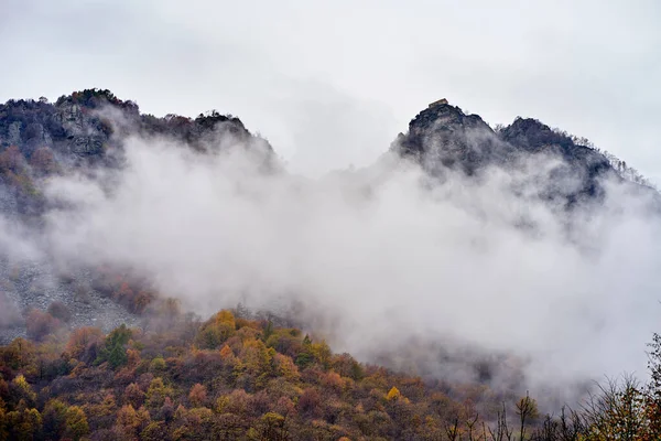 Dvě skály pokryté mraky a mlha v italském Piemonte Stock Snímky