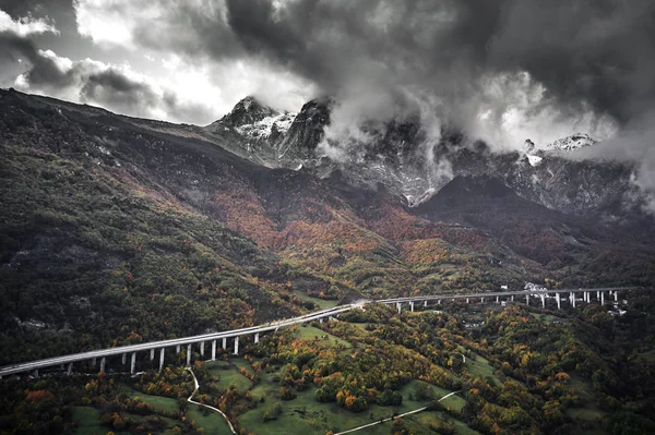 Hög höst alpin hastighet väg i Italien. Flygfoto ovanifrån med moln på bakgrunden — Stockfoto
