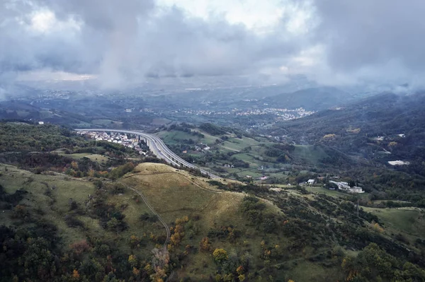 İtalya 'da sonbahar hız yolu. Gökyüzü manzaralı, arka planda bulutlar ve uzak bir köy.
