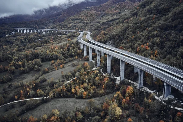 Hoge herfst alpine snelweg in Italië. Luchtfoto van bovenaf met wolken op de achtergrond — Stockfoto