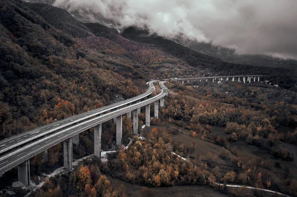 Hoge herfst alpine snelweg in Italië. Luchtfoto van bovenaf met wolken op de achtergrond — Stockfoto