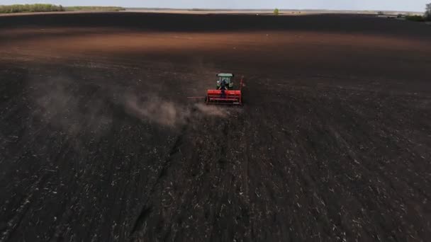 Groene trekker in het veld zaait maïs, luchtfoto — Stockvideo