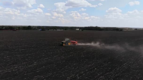 Groene trekker in het veld zaait maïs, luchtfoto — Stockvideo