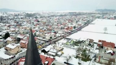 Birçok insan kaldırımlarda duruyor ve kentteki geçit törenini izliyor. Kış geldi..
