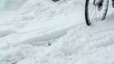 Bir erkek bisikletini çok dikkatli sürmelidir. Kar yağıyor ve yerde zaten çok kar var..