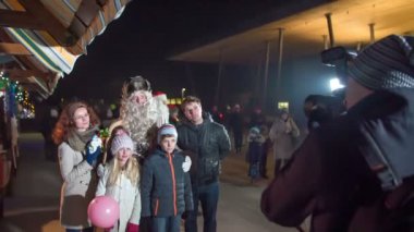 Bir fotoğrafçı Noel Baba 'yla ailesinin Noel pazarında fotoğrafını çekiyor..