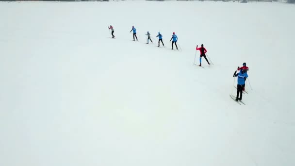 数人が列をなしてクロスカントリースキーをしている 空中射撃だ至る所に雪がたくさんあります — ストック動画