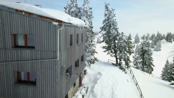一座灰色的木制小木屋 屋顶上和那个地区都有雪 空中射击 现在是冬天了 — 图库视频影像