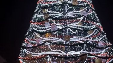 Işıkları ve süsü olan güzel bir Noel ağacı. Gece oldu..