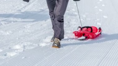 İki adam kızaklarını yukarı çekiyor ve botlarını görebiliyoruz..