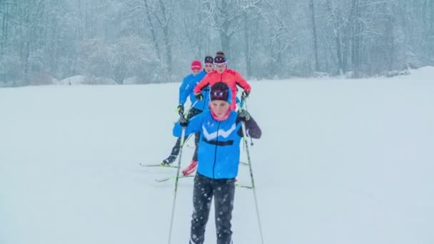 在下雪的日子里 一群人在一排接一排地滑雪 它看起来像它很冷 大家都穿得很暖和 — 图库视频影像