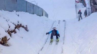 Şirin genç kayak atlayıcıları kayak atlayışlarında pratik yapıyorlar. Kış geldi..