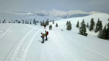 Birkaç alp kayakçısı yüksek bir dağdaki karda dışarıda kaliteli zaman geçiriyorlar. Güzel bir gün. Hava görüntüsü.