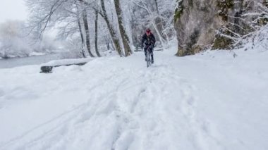 Karlı ve soğuk bir kış gününde bile bir adam antrenman yapıyor. Yol kaygan..