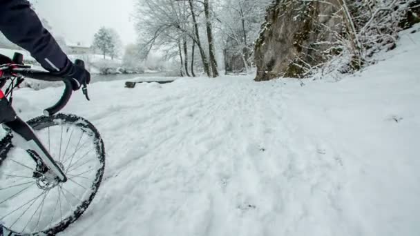 一个人在河边的雪地上骑自行车 这是一个美丽的冬日 — 图库视频影像