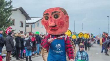 Koca kafalı bir adam elinde çatalla komik şeyler yapıyor..