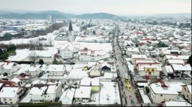 Kış zamanı kostümlü bir festival izleyebiliriz. Hava görüntüsü. Kar her yerde..