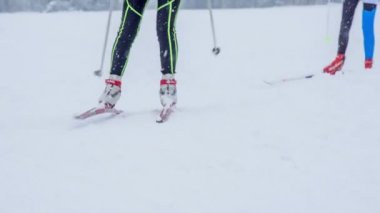 Karlı bir günde iki kişi kayak yapıyor ve sonra dönüş yapıyorlar..