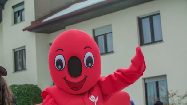 Een Vrolijke Rode Mascotte Beweegt Met Beide Handen Een Parade — Stockvideo