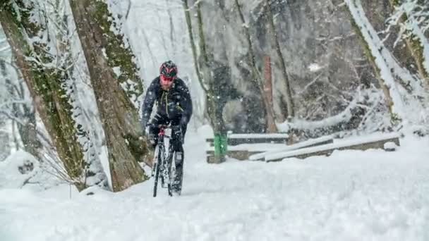 一个骑自行车的人正在雪地里骑自行车上山 因为下雪了 所以很滑 — 图库视频影像