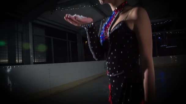 雪はどこでも飛び回るフィギュアスケートが彼女の手からそれを吹くとき — ストック動画