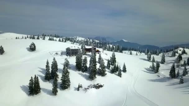 两座木头房子耸立在一座小山的中央 空中射击 风景被雪覆盖着 — 图库视频影像