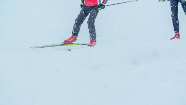 一群人在滑雪时正在转弯 外面看起来很冷 而且还在下雪 — 图库视频影像