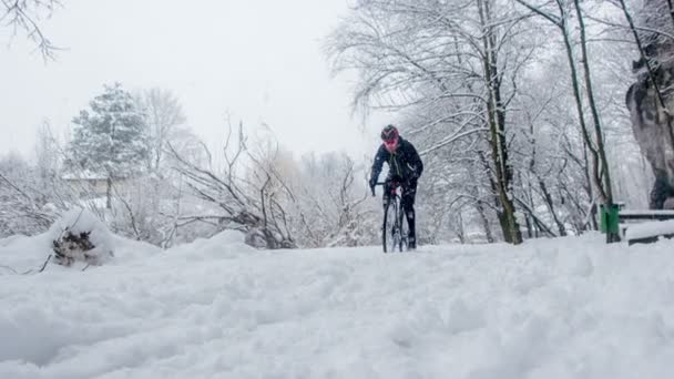 スポーツマンがトレーニング中に自分自身を押していますが 道路は雪で滑りやすいです — ストック動画