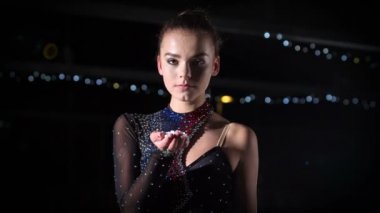 Güzel bir buz patencisi elinden kar üflüyor..