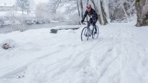 Холодный Снежный Зимний День Спортсмен Равно Катается Велосипеде Природе — стоковое видео