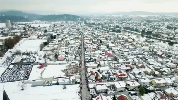 パレードが行われているときに街には雪がたくさんあります 空中射撃だカーニバルは長い通りを進んでいます — ストック動画