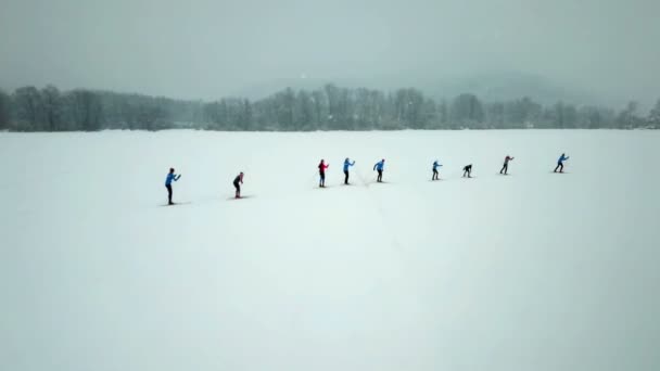 一群人正在进行越野滑雪 我们可以看到他们在跟随领队 空中射击 — 图库视频影像