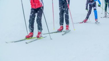 Kayakçılar yan yana kayak yapıyorlar. Kar da yağıyor ama çok iyi vakit geçiriyorlar..