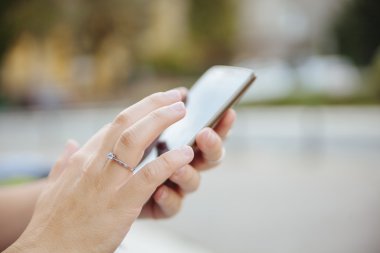 Akıllı telefonu olan genç bir kadın.