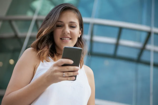 Jovem mulher usando telefone celular — Fotografia de Stock