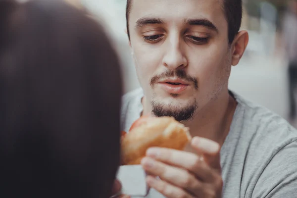 Giovane uomo mangiare un hotdog — Foto Stock