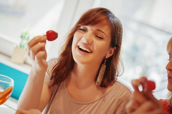Молодые подруги едят клубнику — стоковое фото