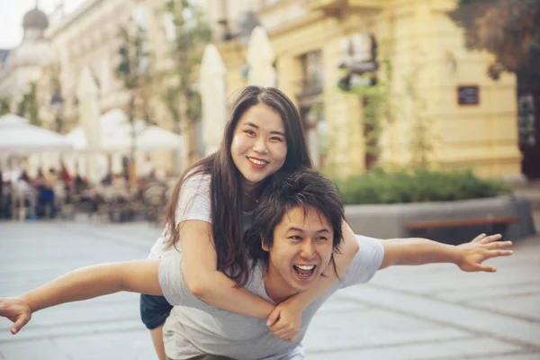 Ζευγάρι Ασίας τουρίστες εκτέλεση piggyback — Φωτογραφία Αρχείου