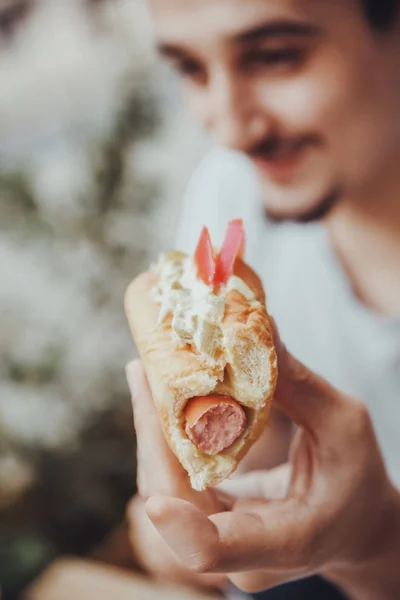 Giovane uomo mangiare un hotdog — Foto Stock