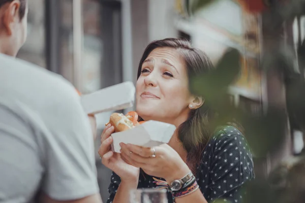 Joven mujer comiendo un perrito caliente —  Fotos de Stock