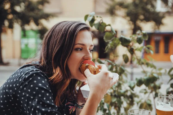 Joven mujer comiendo un perrito caliente — Foto de Stock