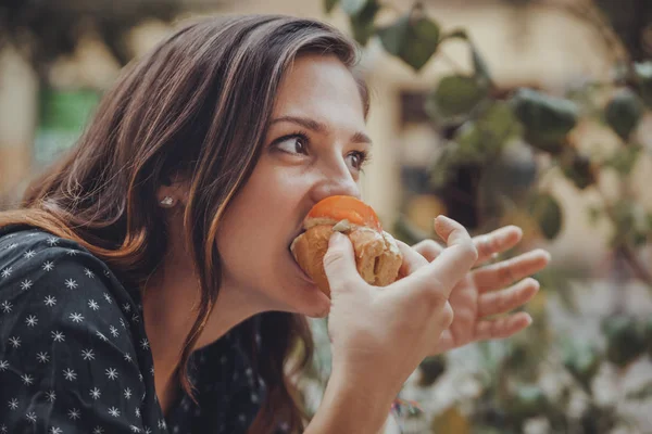 Joven mujer comiendo un perrito caliente — Foto de Stock