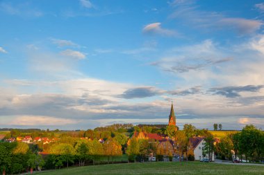 Gietrzwald - Polonya 'nın Warmia ve Mazury bölgesinde bir köy - bahar manzarası, çiçek açan kolza tohumu. Kutsanmış Bakire Meryem 'in Doğumu Bazilikası Gietrzwald' da.